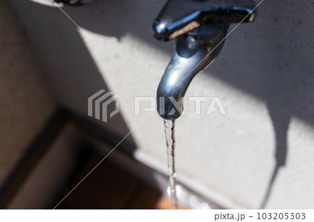 水道の蛇口から流れ落ちる水 103205303