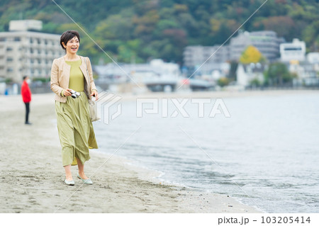 旅行先で海辺を歩くミドル女性 旅行先で海辺を歩くミドル女性 103205414