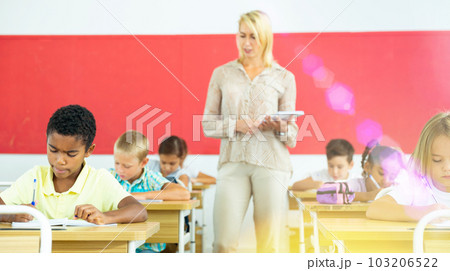 Teacher controlling learning process in primary school 103206522