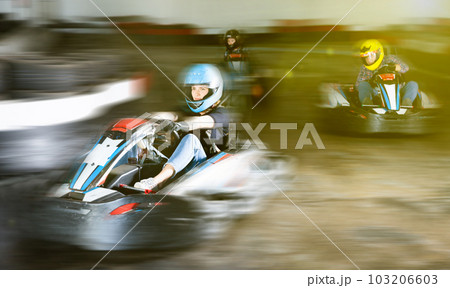 Group of people driving go-carts at racing track Group of people driving go-carts at racing track 103206603