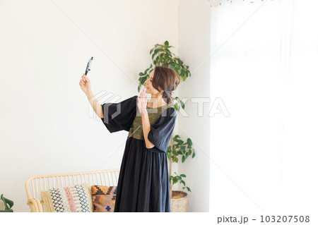 スマホを持って撮影をする女性の写真 スマホを持って撮影をする女性の写真 103207508