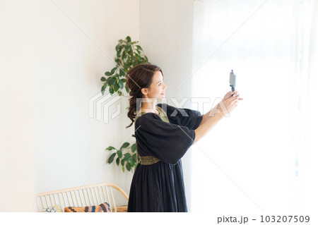 スマホを持って撮影をする女性の写真 スマホを持って撮影をする女性の写真 103207509