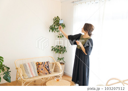 スマホを持って撮影をする女性の写真 スマホを持って撮影をする女性の写真 103207512