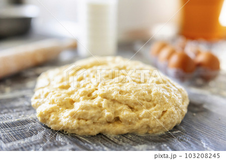 Top view of dough, rolling pin and baking ingredients on a dark wooden table Top view of dough, rolling pin and baking ingredients on a dark wooden table 103208245