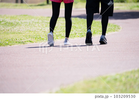 公園でランニングする若いカップルの足元 103209530