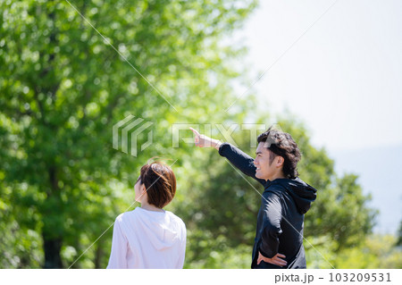 公園で運動中に話をするカップル 103209531