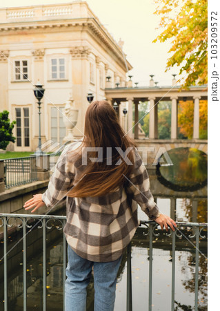 Tourist attraction woman travel enjoying nature sightseeing Baths classicist Palace on the Isle in Lazienki Park touristic place in Warsaw. Lazienki Royal Baths Park, Baroque columns Warsaw Poland Tourist attraction woman travel enjoying nature sightseeing Baths classicist Palace on the Isle in Lazienki Park touristic place in Warsaw. Lazienki Royal Baths Park, Baroque columns Warsaw Poland 103209572