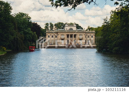 Baths classicist Palace on the Isle in Lazienki Park touristic place in Warsaw. Lazienki Royal Baths Park, Baroque columns Warsaw Poland. Mirror Reflection on the Lake 103211116