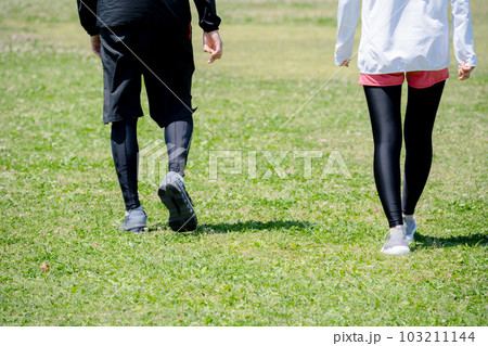 公園で運動する若いカップルの足元 103211144
