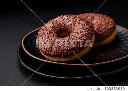 Delicious chocolate glazed donut sprinkled with chocolate chips 103213030