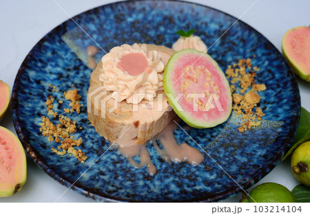 Guava Roll Cake on blue plate on light background with ripe guava fruit 103214104