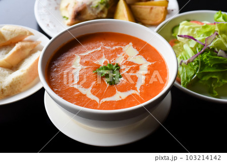 Lunch set made of tomato cream soup, salad, chicken with potato, lemonade on black background 103214142