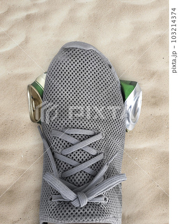 human foot stomp cans flat on the sand, beach, sea human foot stomp cans flat on the sand, beach, sea 103214374