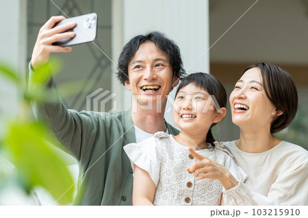 スマホで自撮りをする親子 103215910