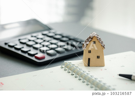 home model on notebook with pen and calculator 103216587
