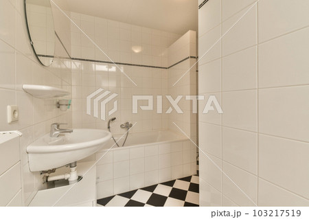 a bathroom with black and white checkered tiles on the floor, sink and mirror in the shower stall area 103217519