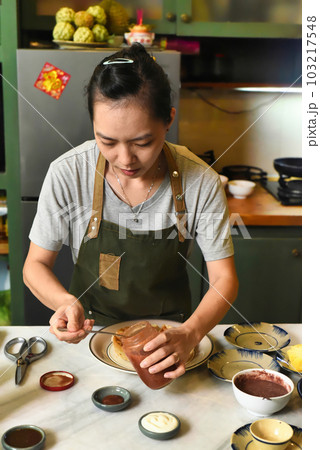Vietnamese woman in apron serving foor on the table 103217548