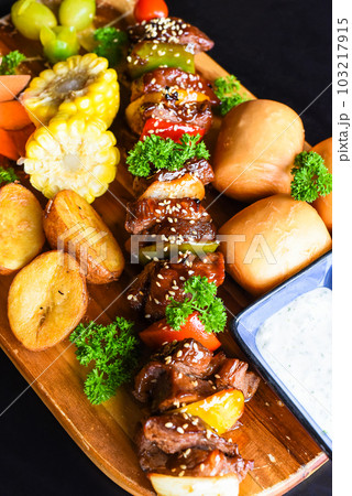 Beef skewers with pepper and corn served with vietnamese buns on black background top view 103217915