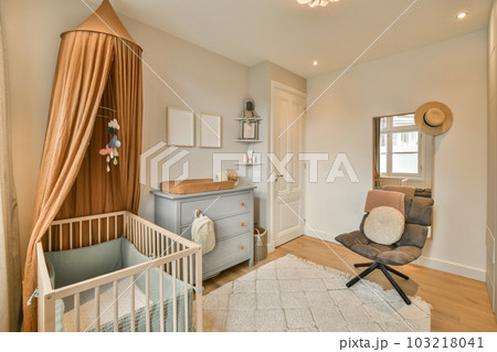 a baby's room with a cribt in the corner and a rocking chair next to the cribt 103218041