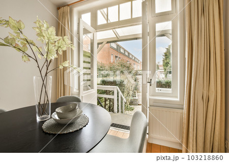 a dining room with a table, chair and window looking out onto the street below it is an outside view a dining room with a table, chair and window looking out onto the street below it is an outside view 103218860