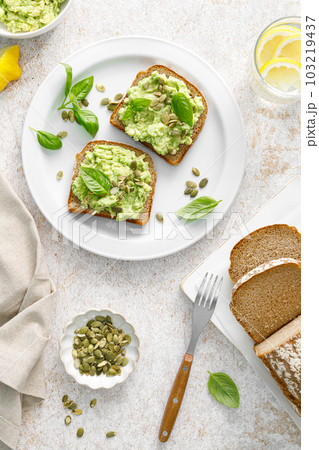 Avocado sandwich with pumpkin seeds. Healthy vegetarian avocado toast with rye bread for breakfast. Vegan menu. Top view 103219437
