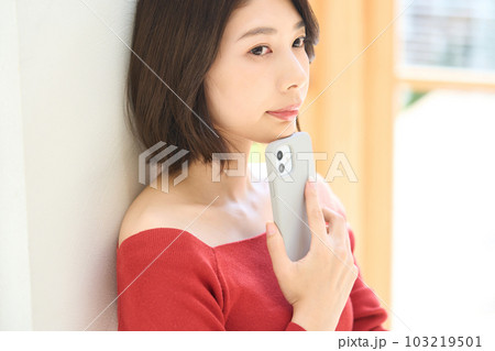 私服の若い女性 リビング スマホ 私服の若い女性 リビング スマホ 103219501