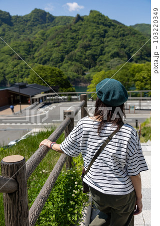川原湯温泉駅と八ッ場あがつま湖を眺める女性 103220349