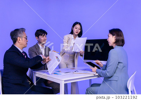 Asian Korean senior, middle aged and young male and female colleagues models in business attire, neon purple studio background, meeting 103221192