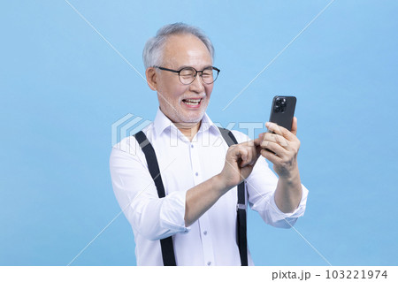 active young senior Korean Asian male looking at smartphone 103221974