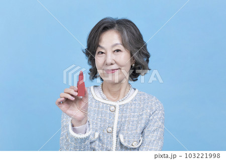 active young senior Korean Asian woman holding lipstick 103221998
