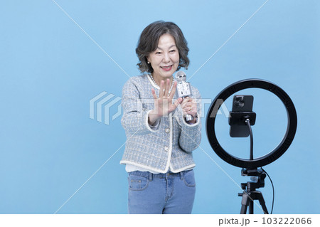 singing active young senior Korean Asian woman with smartphone, mobile karaoke concept singing active young senior Korean Asian woman with smartphone, mobile karaoke concept 103222066