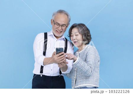 active young senior Korean Asian couple looking at smartphone 103222126