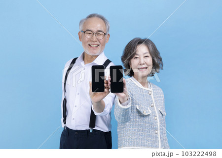 active young senior Korean Asian couple holding smartphone active young senior Korean Asian couple holding smartphone 103222498