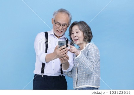 active young senior Korean Asian couple looking at smartphone active young senior Korean Asian couple looking at smartphone 103222613