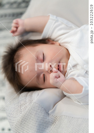 クッションの上で眠っている赤ちゃん クッションの上で眠っている赤ちゃん 103222619