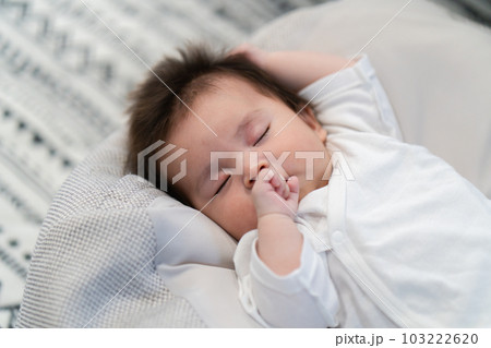 クッションの上で眠っている赤ちゃん クッションの上で眠っている赤ちゃん 103222620