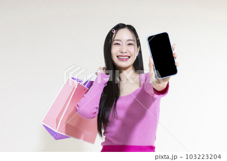 vintage y2k pink retro concept photo of korean asian cute woman holding a smartphone and shopping bags 103223204