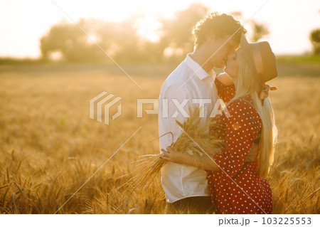 Portrait of young happy couple hugging on the field on the sunset. Enjoying time together. Portrait of young happy couple hugging on the field on the sunset. Enjoying time together. 103225553