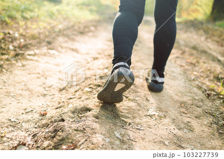 Athlete running on the road trail in sunset training for marathon and fitness. Motion blur of woman exercising outdoors 103227739