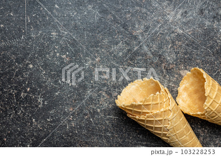 Empty wafer cone. Sweet ice cream cornet on kitchen table. Top view. Empty wafer cone. Sweet ice cream cornet on kitchen table. Top view. 103228253