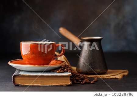 Rich coffee in a cup with aromatic roasted beans 103229796