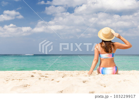 Woman sitting on the sea beach 103229917