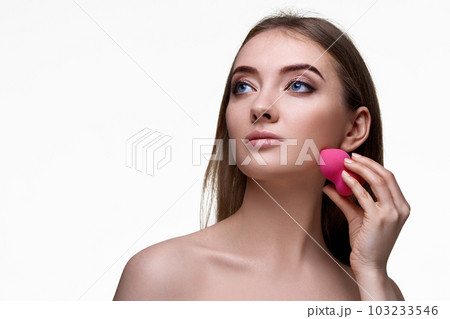 attractive young woman using pink cosmetic sponges attractive young woman using pink cosmetic sponges 103233546
