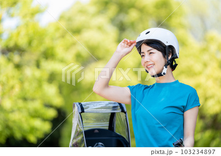 自転車とヘルメットを被る女性。 103234897