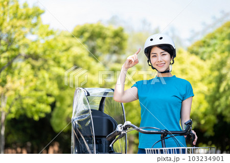 自転車とヘルメットを被る女性。 103234901