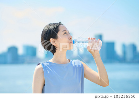ペットボトルに入った水を飲む女性 103236550
