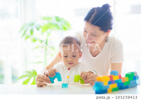 Baby boy  and mother playing with toy 103239413
