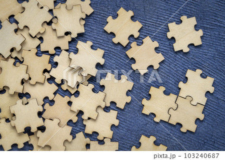 background of blank wooden jigsaw puzzle pieces on blue paper background, completing a task or solving a problem concept background of blank wooden jigsaw puzzle pieces on blue paper background, completing a task or solving a problem concept 103240687