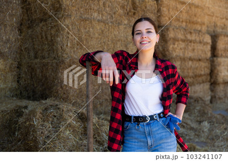 Woman posing at straw storage on farm 103241107