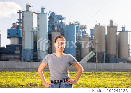 Smiling young girl posing near factory 103241128